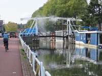 851106 Afbeelding van het met een hogedrukspuit reinigen van de J.P. Coenbrug over de Leidsche Rijn te Utrecht, vanaf ...